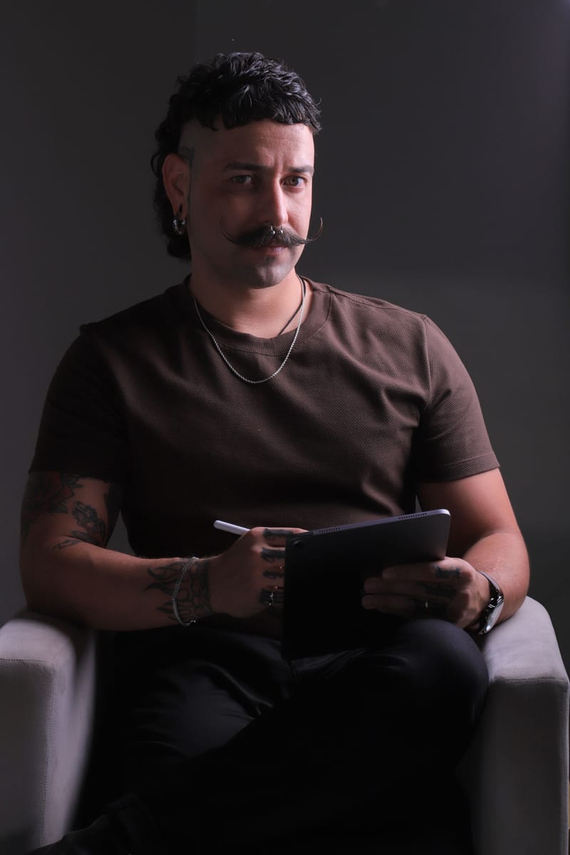 Retrato em preto e branco de Nil olhando para a câmera, sentado em uma poltrona